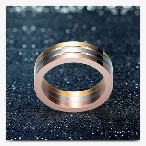 Detail shot of a three-tone stacked ring featuring gold, silver, and rose gold finish bands