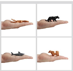 Miniature plastic animal building blocks showing crocodile, shark, and bull in palm of hand