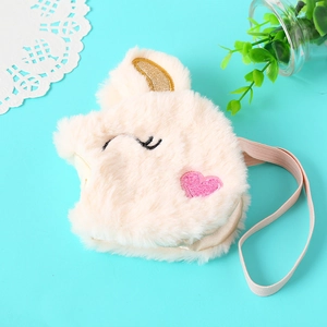 Close-up of unicorn plush crossbody bag with golden horn and pink heart embroidery detail