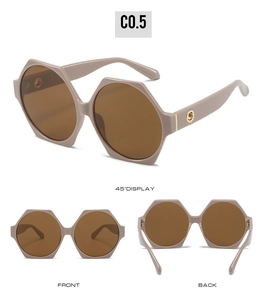 Detail view of pink geometric hexagonal sunglasses with brown lenses and gold metal accents