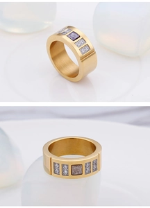 Detailed view of gold titanium ring with purple zircon and brushed metallic texture