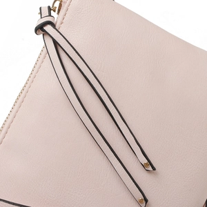 Detailed macro view of the light pink PU leather clutch featuring a zipper and tassel