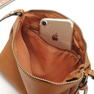 Detail view of the brown faux leather crossbody bag interior with zipper pocket and lining