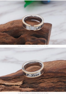 Macro detail of silver steel ring with gold edges, zircon stone and My Love engraving