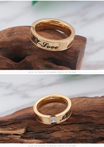 Macro detail of gold-plated couple ring with My Love engraving and square zircon stone