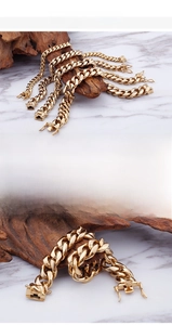 Detail of 18K gold-plated chunky Cuban link bracelet with a high-polished metallic finish