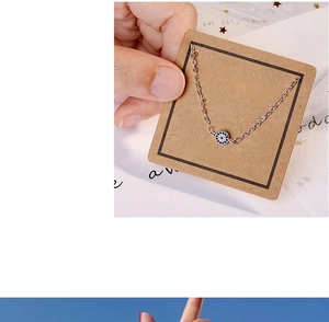 Detailed close-up of blue Evil Eye charm bracelet on a luxury jewelry display card