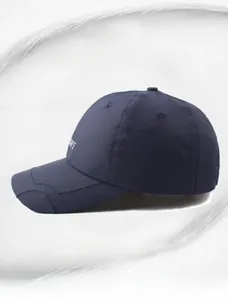 Detail of dark blue quick-dry fabric and embroidered sport logo on outdoor baseball cap