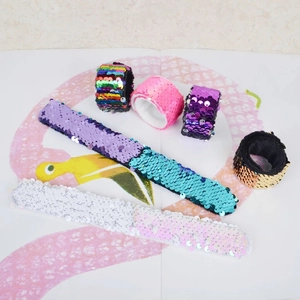 Close-up of colorful sequin slap bracelets in rainbow and glitter finishes for children