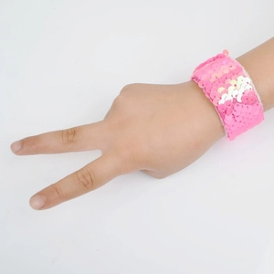 Detailed view of a pink sequin snap bracelet worn on hand making a V-gesture