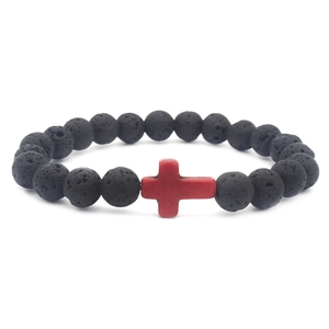 Black lava rock beaded bracelet featuring a red cross charm on a white background