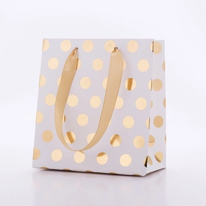 Sac cadeau élégant en papier blanc à pois dorés avec poignées en ruban de soie assorti