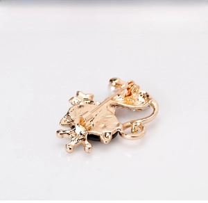 Détail de l'arrière d'une broche chat avec épingle de sûreté dorée et perles blanches