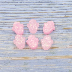 Detail of pink Opal Hamsa hand beads with a glitter finish for DIY jewelry crafting