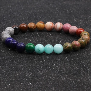 Macro detail of Bohemian multi-color natural stone beads on a textured dark background