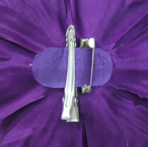 Detail of purple fabric peony flower back with metal duckbill clip and safety pin