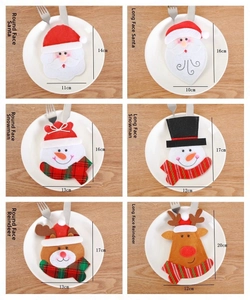 Detail of cartoon Santa, Snowman and Reindeer cutlery holders on white plates