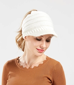 Close-up of white knitted ponytail baseball cap showing thick knit texture on model