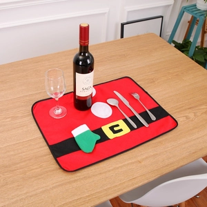 Christmas table mat featuring Santa belt design and glove accents on a wooden dining table