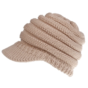 Detail of beige knitted ponytail baseball cap showing thick yarn texture and folded design
