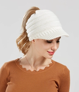 Detail of white knit ponytail baseball cap featuring vertical ribbed texture and open top