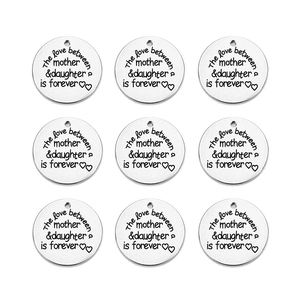 Macro view of 9 silver stainless steel charms with mother and daughter quote engraving