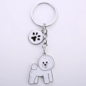 Detail of cute white Bichon dog keychain with silver metal clip and paw print charm