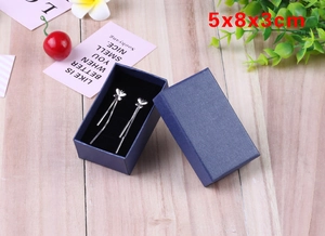 Detail view of silver butterfly tassel earrings in a 5x8x3cm blue linen jewelry box