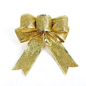 Detailed view of festive golden glitter bow decoration on a white background