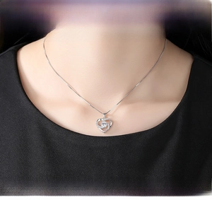 Close-up of elegant S925 silver rotating heart pendant necklace on a model's neck