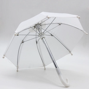 Close-up of a miniature white doll umbrella with metal ribs and curved plastic handle