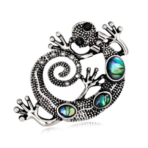 Macro shot of lizard brooch with silver dot texture and blue-green paua shell inlay