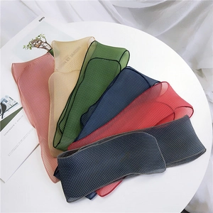 Collection de foulards en mousseline à pois de plusieurs couleurs sur table blanche