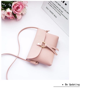 Top view of pink mini crossbody bag with gold ring hardware and leather texture