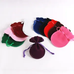 Detailed view of colorful velvet drawstring gift pouches with scalloped ruffle edges