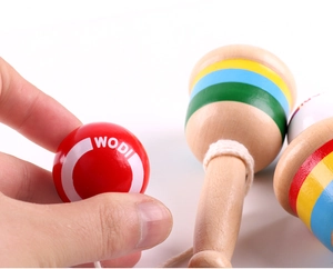 Close-up of a red wooden Kendama ball with WODI print and colorful striped handle