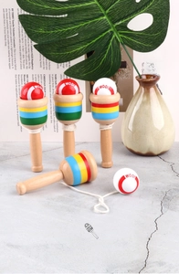 Detailed macro view of wooden kendama skills cup with colorful stripes and red white ball