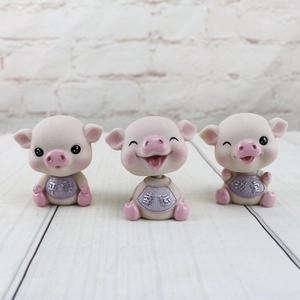 Trois figurines de petits cochons roses en résine avec des mots porte-bonheur sur bois