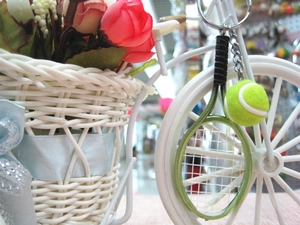 Detail of mini tennis racket and ball keychain set with silver chain and keyring