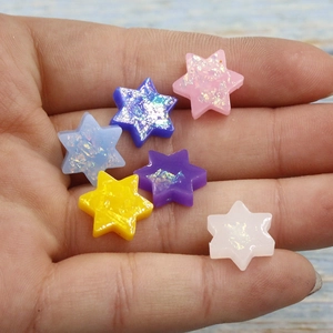 Close-up of vibrant resin opal Star of David charms with sparkling iridescent flakes