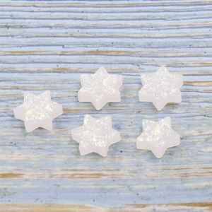 Detailed macro of five white synthetic opal Star of David beads with rainbow shimmer