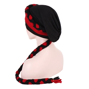 Detail view of red and black braided muslim turban hat with long decorative tassels