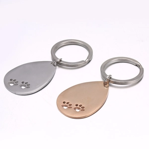 Teardrop stainless steel dog tag keychain with hollow paw prints in silver and rose gold