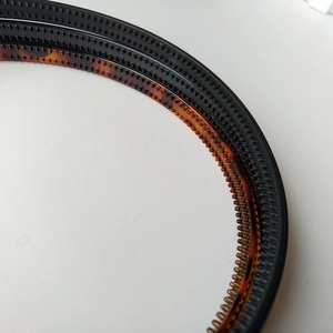 Close-up of non-slip plastic headbands with inner teeth in black and amber colors