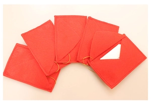 Close-up of red felt Christmas envelope ornaments with gold strings and a card slot