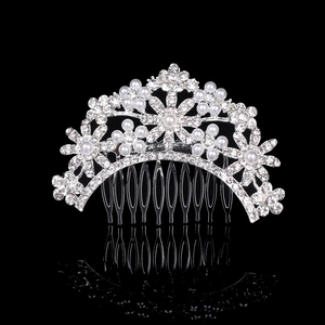 Silver bridal hair comb with pearls and sparkling rhinestones on black background