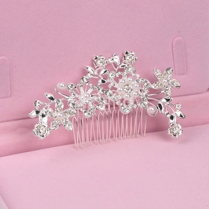 Macro shot of silver bridal flower hair comb with pearls and rhinestones in pink gift box