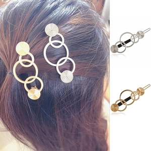 Detail of interlocking circle metal hair clips in gold and silver finishes for women