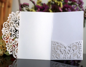 Detail showing white laser-cut lace pattern on pearlescent paper business invitation
