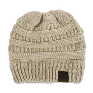 Close-up of beige knit beanie showing wavy texture and ribbed edge with leather patch